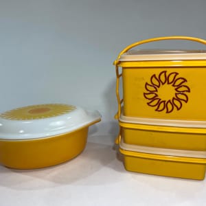 May include: A yellow and white vintage casserole dish and a set of three yellow food storage containers. The casserole dish has a sunflower design on the lid. The containers have a sunflower design and a handle.