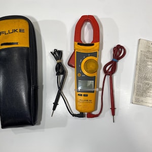 Pu&ograve; includere: Una pinza amperometrica Fluke 336 gialla e nera con ganascia rossa, display digitale e manopola centrale. Sono inclusi puntali di prova neri e rossi, una custodia con cerniera gialla e nera con logo Fluke e una scheda di istruzioni stampata.