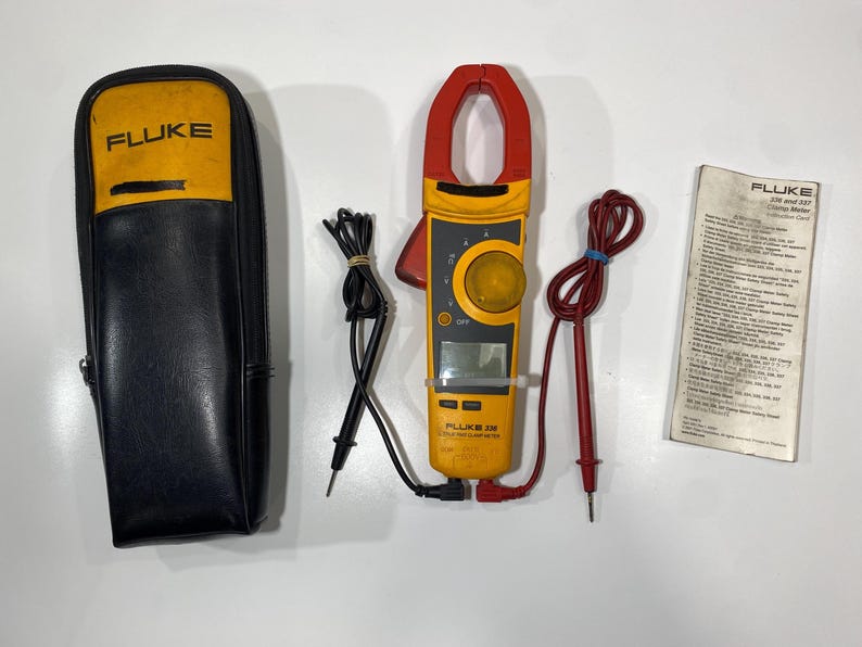 Pu&ograve; includere: Una pinza amperometrica Fluke 336 gialla e nera con ganascia rossa, display digitale e manopola centrale. Sono inclusi puntali di prova neri e rossi, una custodia con cerniera gialla e nera con logo Fluke e una scheda di istruzioni stampata.