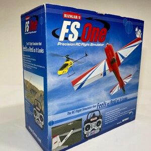 May include: A blue cardboard box for the Hangar 9 FS One Precision RC Flight Simulator. The box features graphics of a red and white airplane, a yellow helicopter, and a remote control transmitter against a blue sky and landscape background.