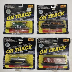 May include: Four Maisto "On Track" die-cast metal train replicas in their original packaging. The train cars include a green locomotive, a black locomotive, a silver tanker car, and a red Santa Fe boxcar.
