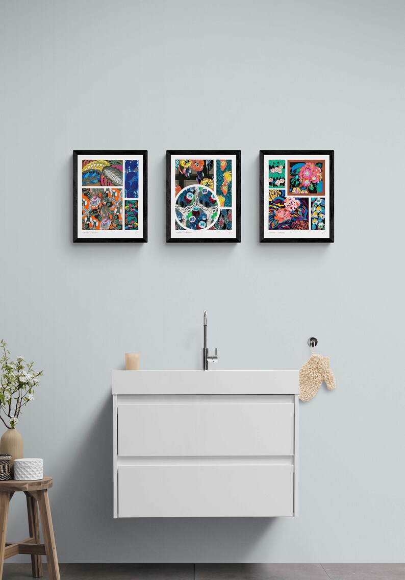 May include: Three framed art prints with colorful floral and abstract designs hang above a white bathroom vanity. The prints feature a variety of patterns and colors, including blues, oranges, and pinks. The frames are black.