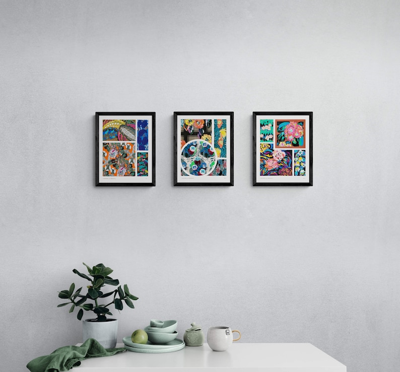 May include: Three framed art prints with black borders hang on a white wall. Each print features a colorful, abstract design with floral and geometric elements. The prints are arranged in a row above a white surface with a plant and tableware.