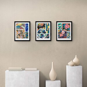 May include: Three framed art prints with black frames are displayed on a beige wall. The prints feature colorful abstract designs with floral and geometric patterns. Decorative vases and a stack of books are on display below the art.