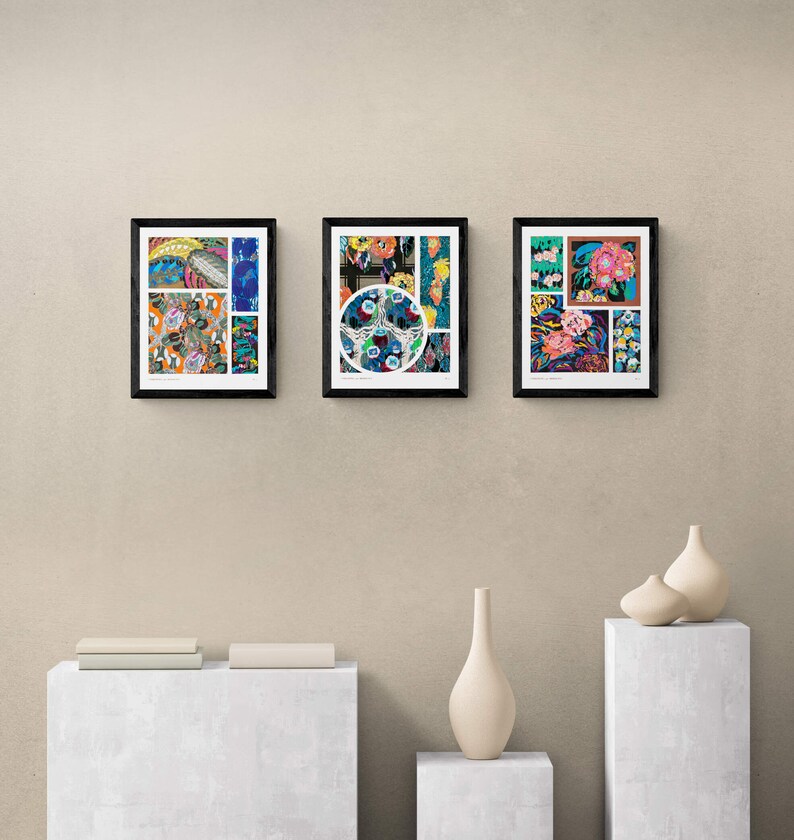 May include: Three framed art prints with black frames are displayed on a beige wall. The prints feature colorful abstract designs with floral and geometric patterns. Decorative vases and a stack of books are on display below the art.