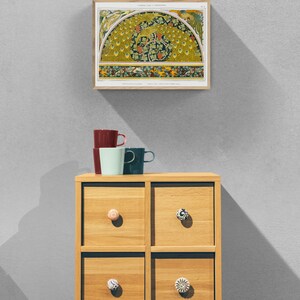 Puede incluir: Una ilustraci&oacute;n bot&aacute;nica vintage de un pavo real con un dise&ntilde;o verde y amarillo. La impresi&oacute;n est&aacute; enmarcada y se muestra en una pared sobre una c&oacute;moda de madera con cajones.