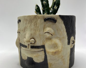 Ceramic plant pot with human face