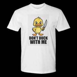 Könnte beinhalten: Weißes T-Shirt mit einer Cartoon-Ente, die ein Messer hält und einen wütenden Gesichtsausdruck hat. Der Text "DON'T DUCK WITH ME" ist unter der Entenillustration in fetten, schwarzen Buchstaben aufgedruckt. Ein lässiges Kleidungsstück.