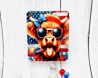 Peut inclure: Une vache rouge, blanche et bleue avec des lunettes de soleil et un nœud sur la tête. La vache porte un bandana rouge et a un feu d'artifice dans sa bouche. La vache est sur un fond blanc avec un fond rouge, blanc et bleu.