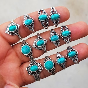 May include: A set of 12 silver rings with turquoise stones. The rings are all different designs, but they all have a similar style. They would make a great gift for someone who loves turquoise jewelry.