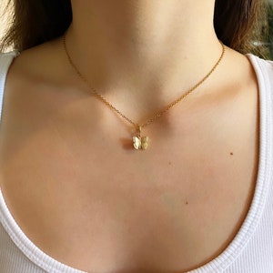 May include: A gold chain necklace with a small butterfly pendant.