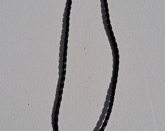 Glass vial with stopper pendant on brown braided leather cord necklace