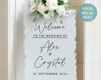 May include: A light blue wedding welcome sign with white flowers on top. The sign says "Welcome to the wedding of Alex + Crystal 10 September 2022".