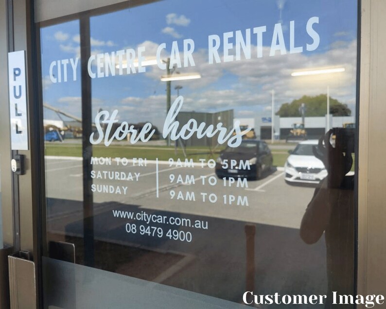K&ouml;nnte beinhalten: Eine Glast&uuml;r mit einem wei&szlig;en Schild, auf dem "CITY CENTRE CAR RENTALS" und "Store hours" steht. Das Schild listet die Gesch&auml;ftszeiten von Montag bis Freitag, Samstag und Sonntag auf. Die Telefonnummer und die Website sind ebenfalls auf dem Schild angegeben.