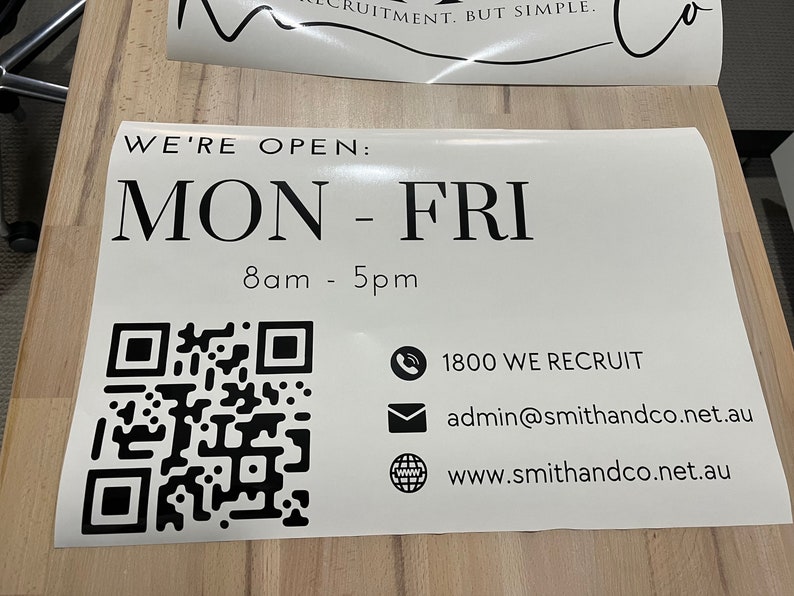 K&ouml;nnte beinhalten: Ein wei&szlig;es Schild mit schwarzem Text, auf dem steht "WE'RE OPEN: MON - FRI 8am - 5pm". Ein schwarz-wei&szlig;es QR-Code befindet sich in der linken unteren Ecke. Das Schild enth&auml;lt auch ein Telefonsymbol mit dem Text "1800 WE RECRUIT", ein E-Mail-Symbol mit dem Text "admin@smithandco.net.au" und ein Globussymbol mit dem Text "www.smithandco.net.au".