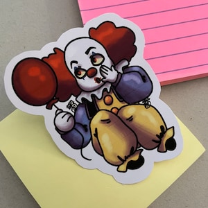 May include: A sticker of a cartoon clown with red hair, a white face, and a red nose. The clown is holding a red balloon and has a surprised expression on its face.