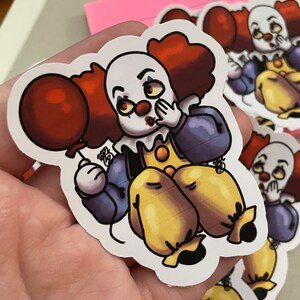 May include: A sticker of a cartoon clown with red hair, a red balloon, and a blue and purple outfit. The clown is holding its hand over its mouth and has a surprised expression on its face.