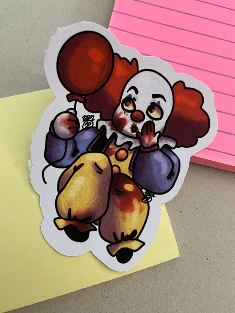 May include: A sticker of a cartoon clown with red hair, a white face, and a red balloon. The clown is wearing a blue and yellow costume and has a surprised expression. The sticker is on a yellow background.