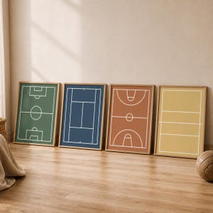 Peut inclure: Quatre affiches encadrées de terrains de sport : football, tennis, basket-ball et volley-ball. Chaque affiche présente un design minimaliste avec des lignes blanches sur un fond coloré, vert, bleu, marron et jaune. Les cadres sont en bois naturel.