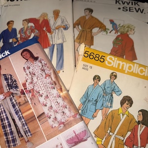May include: A collection of vintage sewing patterns for robes and loungewear, featuring various illustrations of people wearing belted wrap-style garments in floral, plaid, and solid colors, with printed text including Kwik Sew and Simplicity 5685.