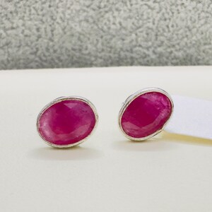 Puede incluir: Un par de pendientes de plata con piedras preciosas rosadas de forma ovalada.