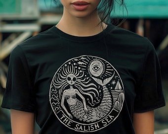 May include: Black t-shirt featuring a white graphic print of a mermaid with a crown of seaweed and the text "The Salish Sea".