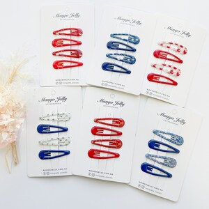 Könnte beinhalten: Sechs Sets mit Haarklammern auf weißen Karten. Jedes Set enthält vier Klammern mit einem roten, weißen und blauen Blumenmuster. Die Karten tragen den Text "Mango Jelly Accessories" und die Website-Adresse "mangojelly.com.au".