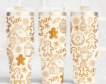 Op de afbeelding: Drie witte bekers met gouden deksels en rietjes. Elke beker heeft een ander patroon van gouden peperkoekmannetjes, snoepstokken, sneeuwvlokken en andere kerstthema-ontwerpen.