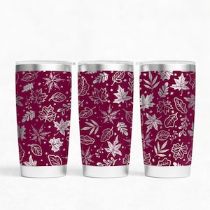 Puede incluir: Tres vasos de acero inoxidable con base burdeos y un patrón plateado de hojas y ramas.