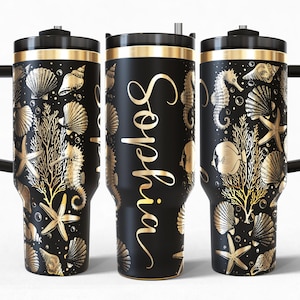 Op de afbeelding: Zwarte reismok met een gouden zeelevenontwerp, inclusief schelpen, zeepaardjes en zeesterren. De naam "Sophia" staat in gouden script op de zijkant. De mok heeft een zwart handvat en een gouden rand.