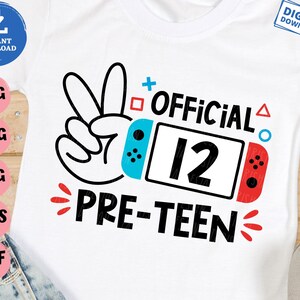 May include: A white t-shirt with a black and white peace sign, a blue and red video game controller, and the text "OFFICIAL 12 PRE-TEEN".