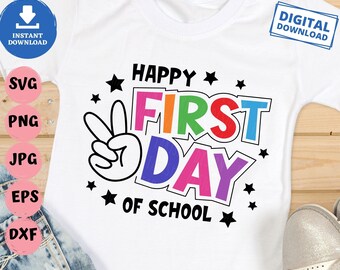 May include: A white t-shirt with a colorful graphic that says "Happy First Day of School". The graphic includes a peace sign, stars, and the words "Happy", "First", "Day", and "of School" in rainbow colors.