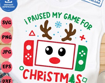 May include: White t-shirt with a Christmas-themed graphic. The design features a game console with reindeer antlers, the text "I PAUSED MY GAME FOR CHRISTMAS," and a snowflake. The shirt also has the words "DIGITAL DOWNLOAD" and file type icons.