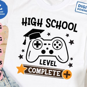 Könnte beinhalten: Ein weißes T-Shirt mit einer schwarz-weißen Grafik eines Videospiel-Controllers und einer Abschluss-Kappe. Der Text "HIGH SCHOOL LEVEL COMPLETE +" ist auf das T-Shirt gedruckt.