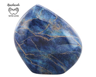 May include: A blue and gold ceramic urn shaped like a smooth, rounded stone. The urn has a marbled pattern with gold veins.
