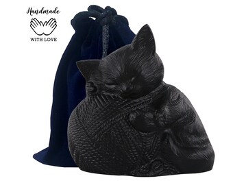 May include: Black ceramic cat figurine curled up sleeping, with a blue velvet drawstring bag. The bag has the text "Handmade with Love" and two hands forming a heart.