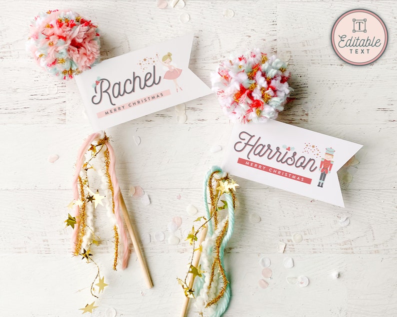 May include: White place cards with the names "Rachel" and "Harrison" and the words "Merry Christmas". The "Rachel" card has a ballerina graphic, and the "Harrison" card has a nutcracker graphic. The image also shows pom-poms and star wands.
