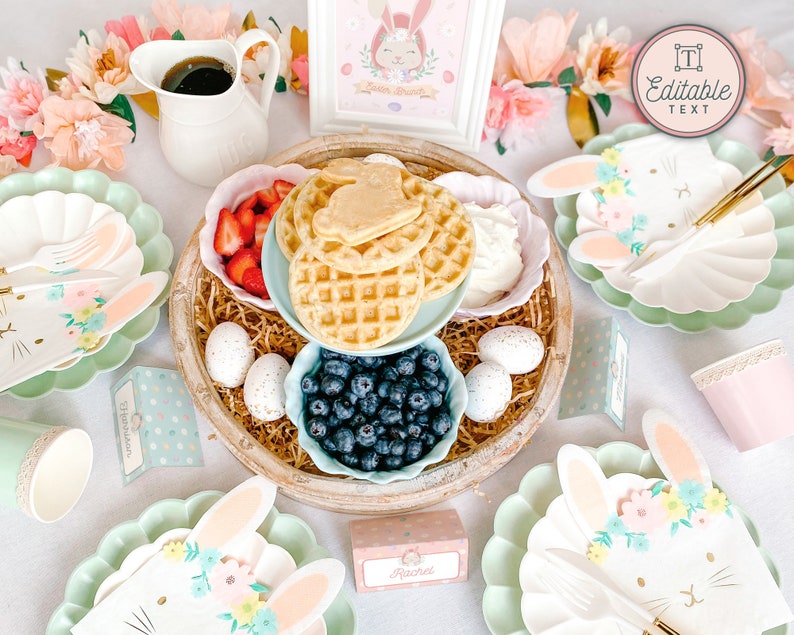 Pu&ograve; includere: Una tavola apparecchiata per un brunch con una tavolozza di colori pastello. La tavola &egrave; decorata con piatti, tovaglioli e un centrotavola a tema coniglietto, con waffle, frutta e mirtilli. Il centrotavola &egrave; circondato da fiori rosa e verdi pastello. La tavola include anche un cartello che dice "Testo modificabile".