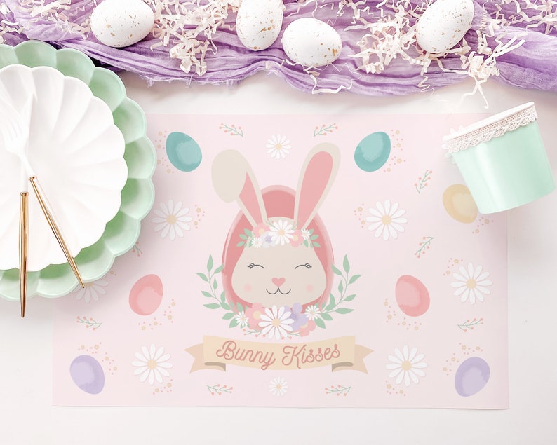 May include: Pink bunny rabbit with a floral crown and the text "Bunny Kisses" on a pink placemat with a white background and pastel colored eggs.
