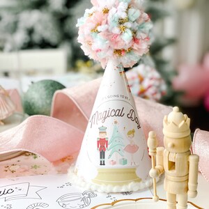May include: A party hat with a pom-pom top and the text "It's Going to Be a Magical Day." The hat features illustrations of a nutcracker, Christmas tree, and ballerina. A wooden nutcracker figurine is also present.