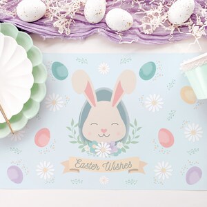 May include: A blue and white placemat with a cartoon bunny rabbit, flowers, and pastel colored eggs. The text "Easter Wishes" is printed on the placemat.