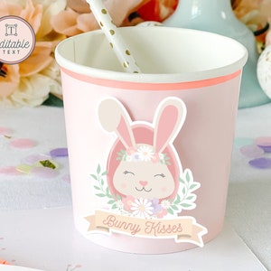 May include: Pink paper cup with a bunny sticker. The sticker features a pink bunny with a flower crown and the text "Bunny Kisses".
