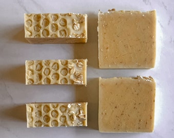 May include: Four bars of soap, two with a honeycomb pattern and two with a plain surface. The soap is a light beige color.