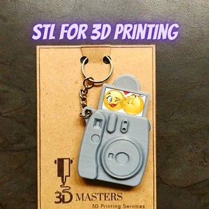 May include: A gray 3D printed camera keychain with a small photo insert featuring a cartoon couple. The keychain is on a brown background with the text "STL FOR 3D PRINTING" and "3D MASTERS 3D Printing Services".
