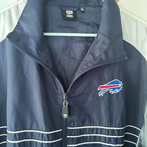May include: Navy blue NFL Buffalo Bills jacket with a full zipper and white stripes. The jacket features the team logo on the chest and the NFL and Reebok logos. Size XL.