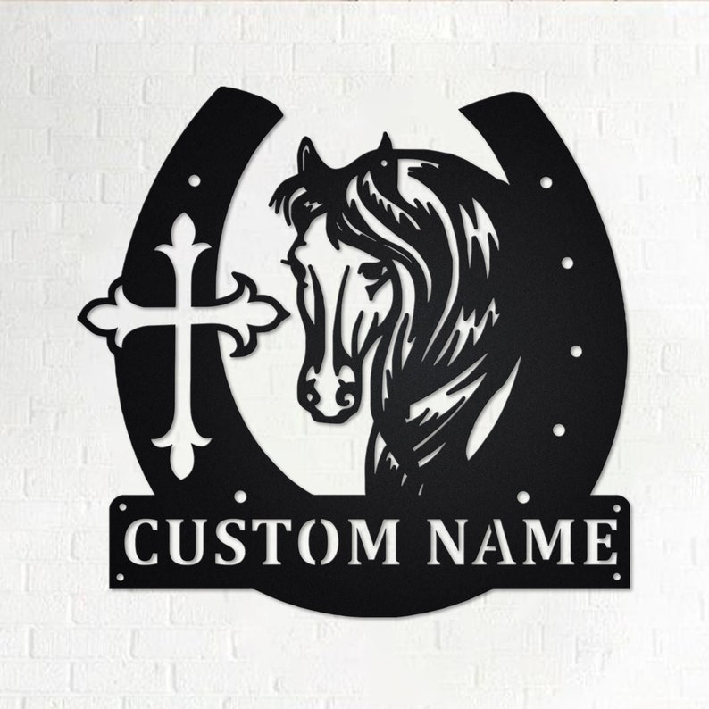 May include: Black metal horseshoe with a horse head silhouette and a cross design. The horseshoe has a personalized nameplate that reads "CUSTOM NAME".