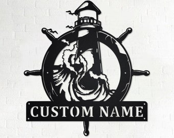 Può includere: Arte da parete in metallo nero con un faro, un'onda e un timone di nave. L'opera d'arte include una targhetta personalizzata con il nome "CUSTOM NAME".