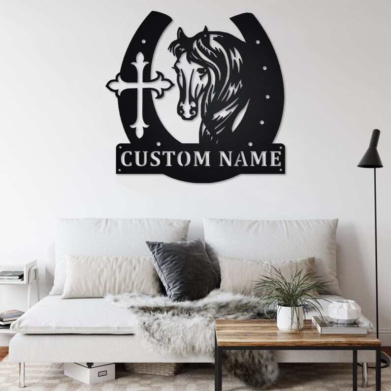 May include: Black metal wall art featuring a horse head inside a horseshoe with a cross on the left side. The art includes the text "CUSTOM NAME" at the bottom.