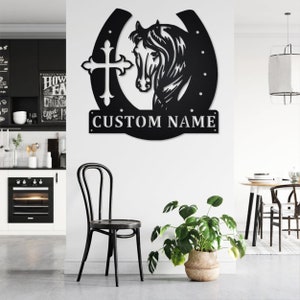 May include: Black metal wall decor featuring a horseshoe with a cross and a horse head silhouette. The text "CUSTOM NAME" is displayed below the horseshoe.