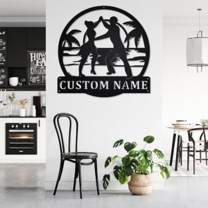May include: Black metal silhouette of a couple dancing on a beach with palm trees. The silhouette is in a circle with the text "CUSTOM NAME" below it.